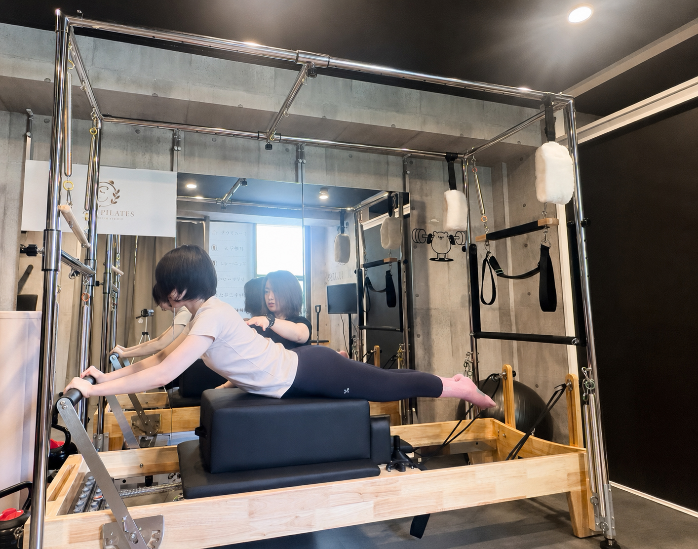 トレーナーのサポートを受けながら行うマシンピラティスレッスン