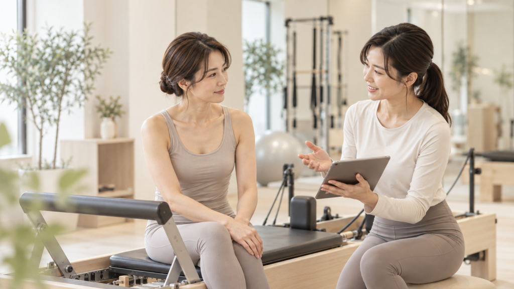 ピラティスの時間帯についてトレーナーに相談する女性