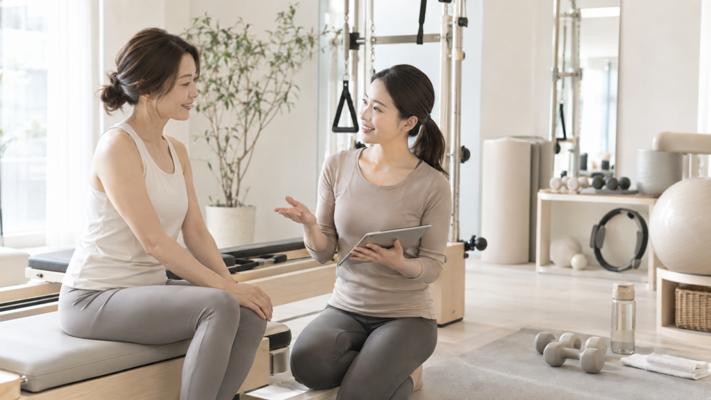 ピラティスと筋トレの組み合わせをトレーナーと相談する女性