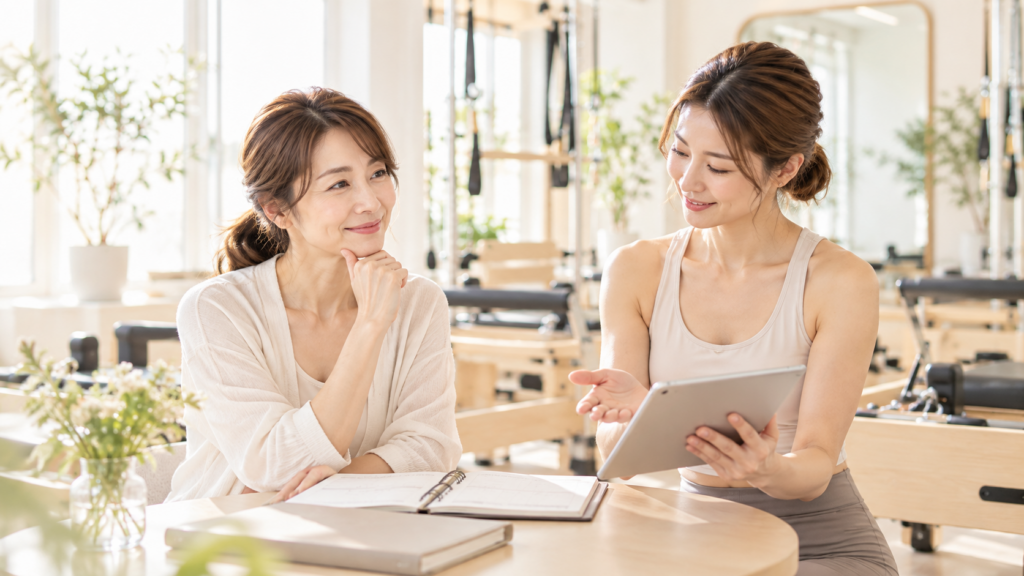 40代女性がピラティスの通う頻度をトレーナーと相談する様子
